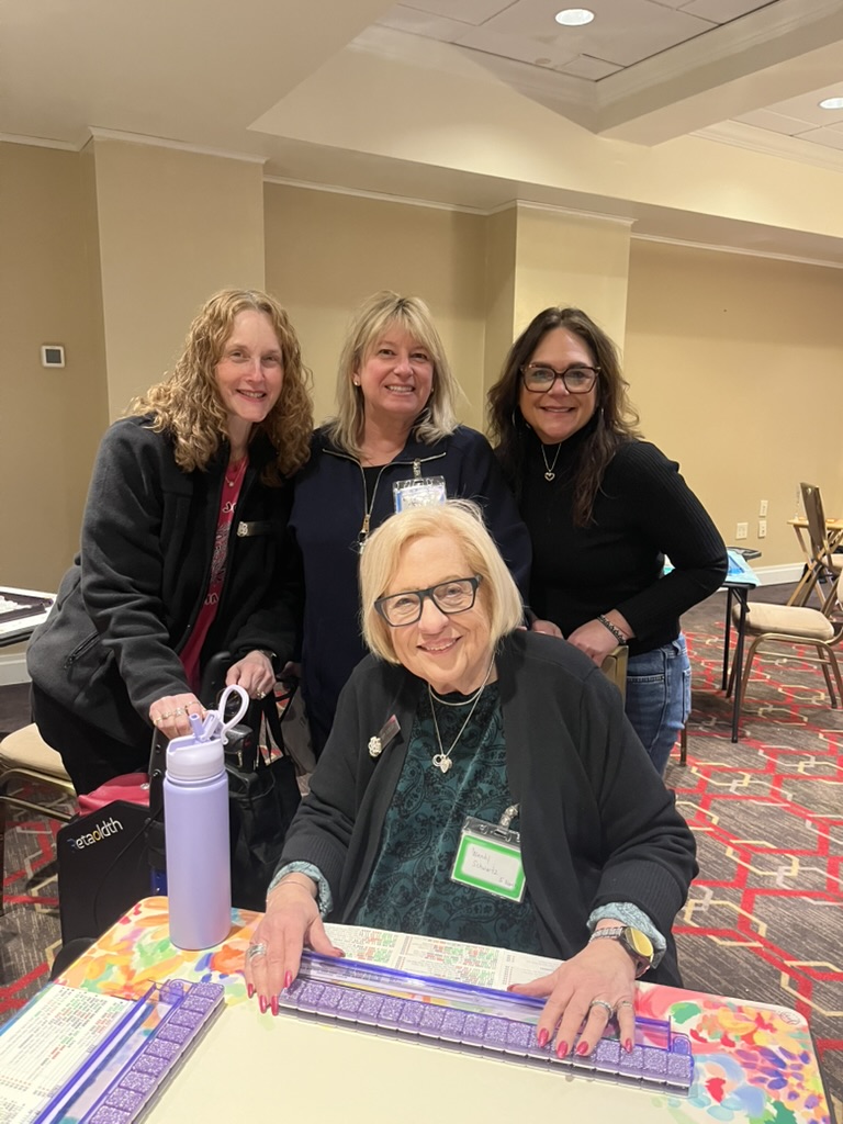 Friends gathered around a Mah Jongg table at a Mah Jongg Mania event